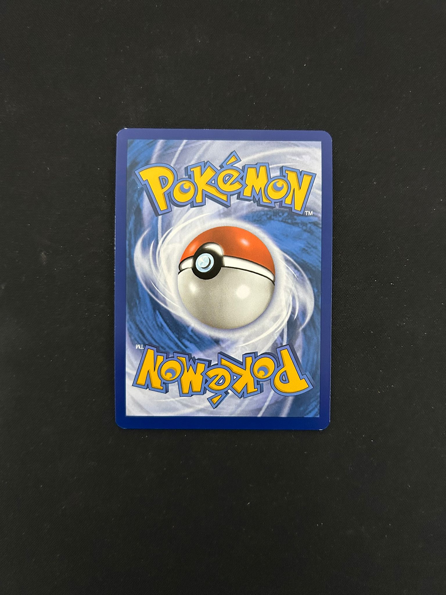 Back side of a Pokémon TCG card, featuring the iconic blue background with a swirling pattern and a centered Poké Ball design. The word 'Pokémon' is displayed in bold yellow lettering at the top and bottom, maintaining the classic look of official Pokémon trading cards.